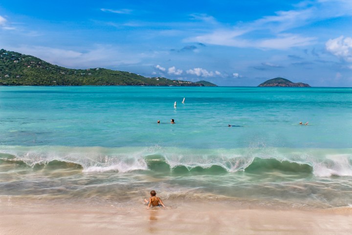 a group of people on a beach near a body of water