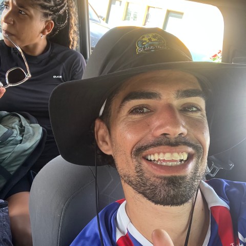 a man wearing a hat and smiling at the camera