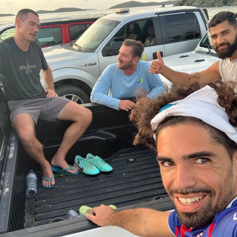 a group of people sitting around a car