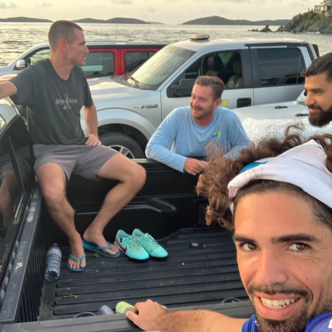 a group of people sitting around a car